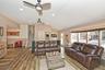 Living room with stairway, recessed lighting, wood finished floors, lofted ceiling, and ceiling fan