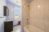 Full bathroom with vanity, radiator, shower / tub combination, and light tile patterned flooring