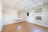 Unfurnished room with radiator heating unit, wood finished floors, and a drop ceiling