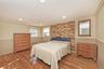 Bedroom with ornamental molding, light wood finished floors, radiator, and recessed lighting