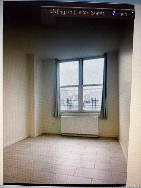Spare room featuring radiator heating unit and wallpapered walls