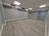 Finished below grade area with light wood-style flooring and baseboards