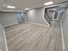Finished below grade area featuring stairway and light wood-style floors