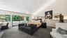 Primary Bedroom Featuring Custom Wool Carpet, High Vaulted Ceilings, and Sliders To Private Balcony