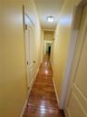 Hallway with hardwood / wood-style flooring