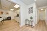 Corridor featuring a paneled ceiling and light wood finished floors