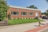 View of front of house with a front yard and brick siding