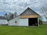 View of barn featuring a yard and a storage shed