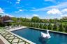 View of swimming pool with a patio and view of wooded area
