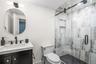 Full bath featuring vanity and a marble finish shower