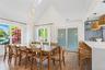 Dining area with high vaulted ceiling, light wood-style flooring, and plenty of natural light