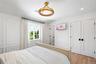 Bedroom with a decorative wall, wood finished floors, lofted ceiling, recessed lighting, and a closet