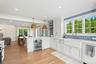 Kitchen featuring pendant lighting, white cabinets, wine cooler, a peninsula, and crown molding