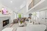 Living area featuring a premium fireplace, high vaulted ceiling, wood finished floors, and recessed lighting