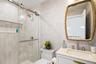 Bathroom featuring wallpapered walls, vanity, and a stall shower