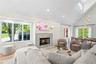 Living area with healthy amount of natural light, high vaulted ceiling, a high end fireplace, wood finished floors, and recessed lighting