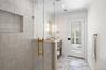 Full bathroom with light marble finish flooring, vanity, a shower stall, ornamental molding, and recessed lighting