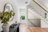 Entryway with ornamental molding, light wood finished floors, and stairs