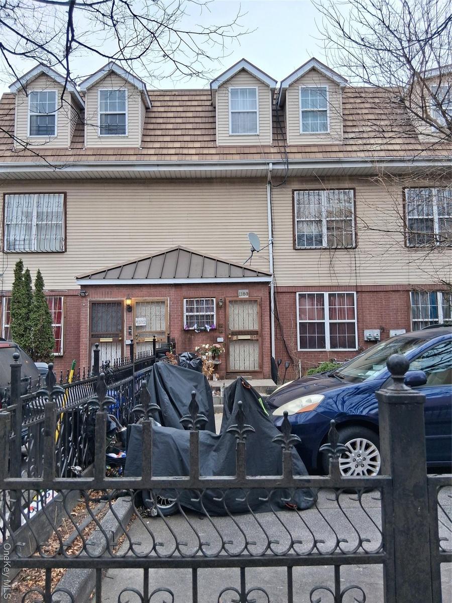 View of front facade featuring brick siding and a fenced front yard