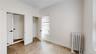 Unfurnished bedroom with radiator heating unit, light wood finished floors, and a closet