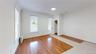 Unfurnished room featuring light wood-style flooring and radiator heating unit