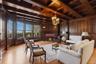 Parlor with a wood ceiling with exposed beams,  chandelier, and brick fireplace, original oak flooring