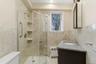 Full bathroom featuring ceramic tile walls and floor,  vanity & shower