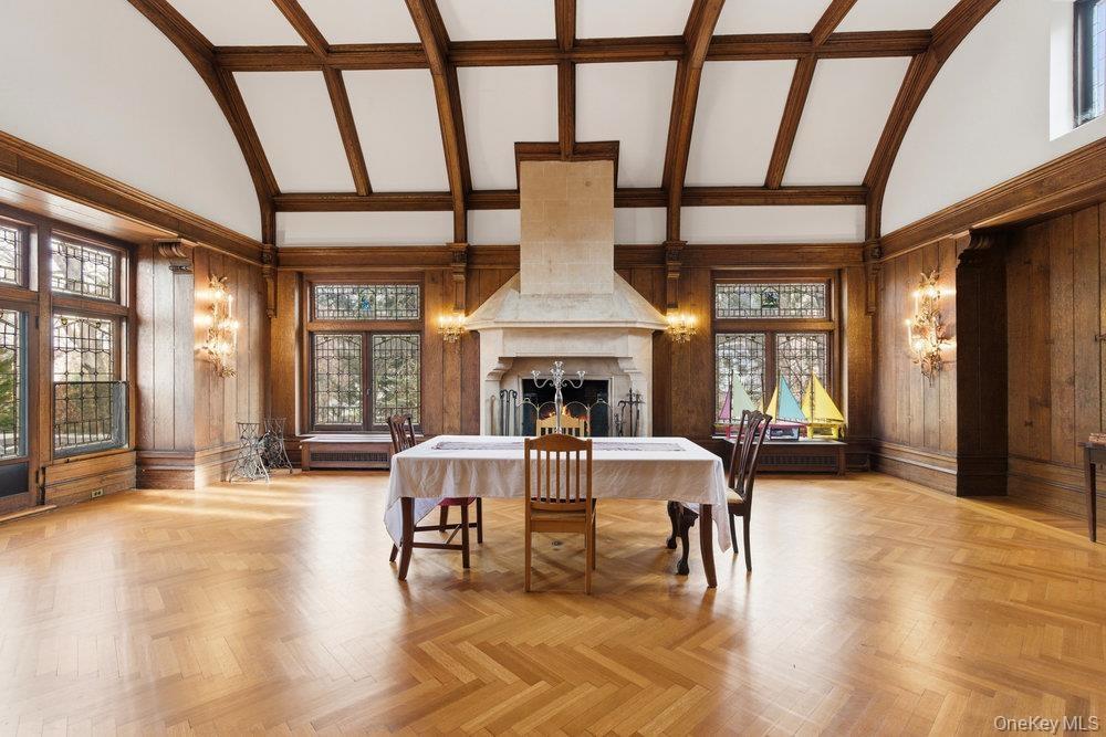 Banquet sized Dining room featuring high vaulted ceiling, old growth forest wood walls, plenty of original herringbone oak floors, tons natural light,