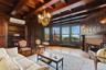 parlor featuring a fireplace,  exposed beam ceiling, a custom mermaid chandelier, and original oak floors