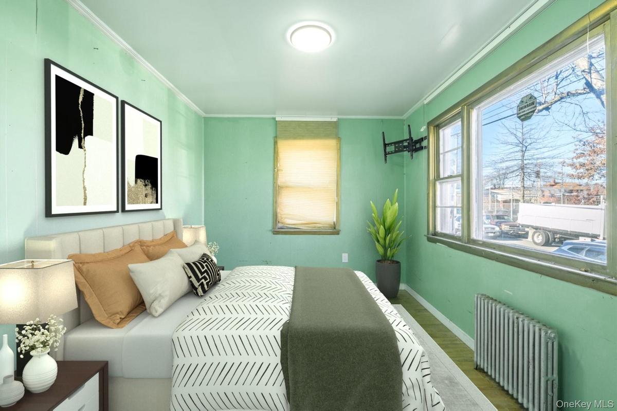 Bedroom with radiator, wood finished floors, and ornamental molding