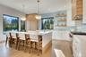 Kitchen featuring double oven range, open shelves, modern cabinets, custom exhaust hood, and tasteful backsplash
