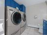 Washroom with light tile patterned floors, baseboard heating, separate washer and dryer, and tile walls