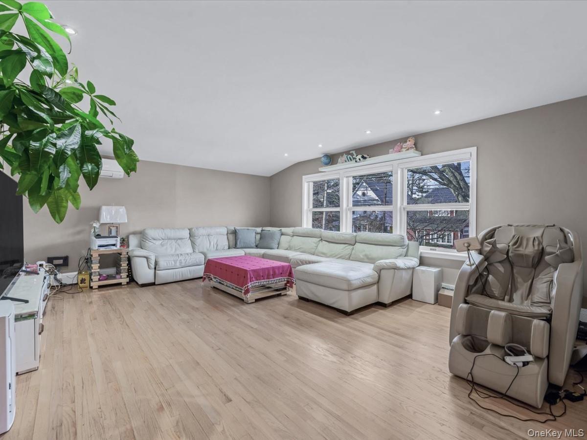 Living area with light wood-type flooring and recessed lighting