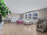Living area with light wood-type flooring and recessed lighting