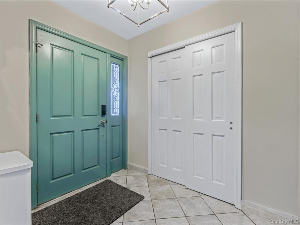 Entrance foyer featuring light tile patterned floors and a chandelier
