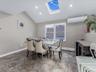 Dining space with a skylight, an AC wall unit, recessed lighting, lofted ceiling, and a baseboard heating unit