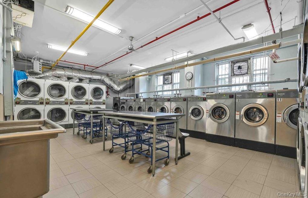 Shared laundry room featuring stacked washer / drying machine, a heating unit, and washing machine and dryer