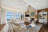 Living area with built in features, a stone fireplace, dark wood-type flooring, high vaulted ceiling, and recessed lighting