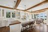 Kitchen featuring white cabinetry, pendant lighting, butcher block counters, plenty of natural light, and beam ceiling