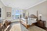 Bedroom with a wainscoted wall, ornamental molding, a water view, a decorative wall, and recessed lighting