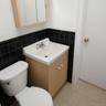 Bathroom featuring tile walls, vanity, light tile patterned flooring, and a wainscoted wall
