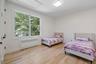 Bedroom featuring radiator, light wood finished floors, and attic access