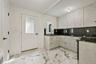 Kitchen with dark stone counters, light marble finish flooring, range with gas cooktop, backsplash, and modern cabinets