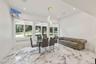 Dining room with radiator heating unit, light marble finish flooring, and recessed lighting