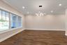 Unfurnished room with dark wood-type flooring, crown molding, recessed lighting, and a chandelier