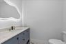 Half bath with vanity and light marble finish flooring