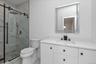 Full bath with vanity, a marble finish shower, and light marble finish floors