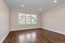 Spare room featuring dark wood-type flooring, crown molding, and recessed lighting
