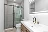 Bathroom with vanity, a stall shower, and light marble finish flooring