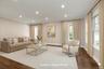 Living area featuring dark wood finished floors, ornamental molding, recessed lighting, and plenty of natural light